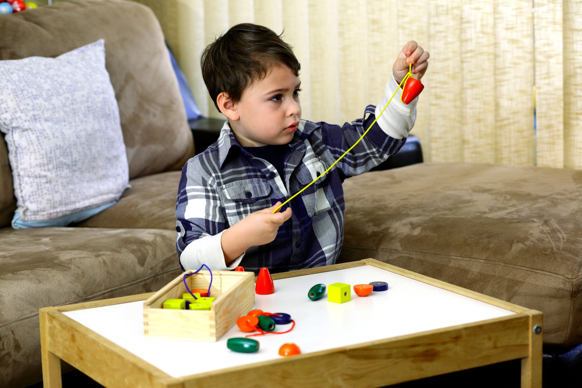 Boy threading a string of beads